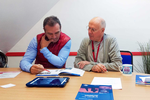 Mature students preparing for Trinity SELT exam with teacher