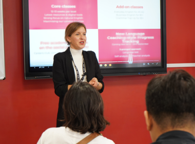 professionelt udseende kvinde stående foran bord med præsentation