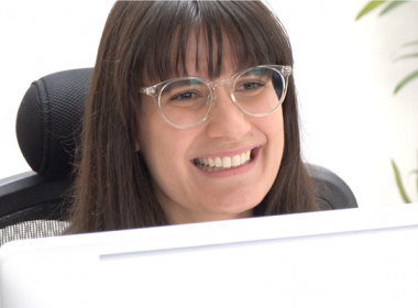 รูปภาพของผู้หญิงยิ้มอยู่บนหน้าจอคอมพิวเตอร์สีขาว